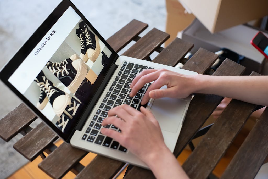 Close-up of Person Using a Laptop and Creating a Fashion Collection